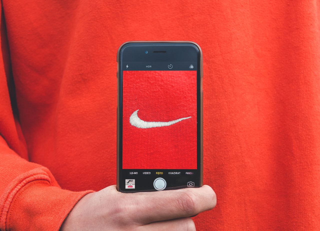 red nike hoodie and an iphone taking a photo