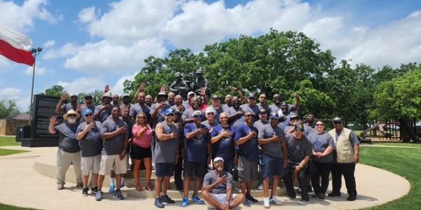 Group of people posing outdoors near a monument.