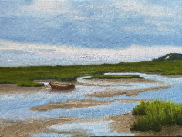 Serene river landscape with a boat and green marshes under a blue sky.