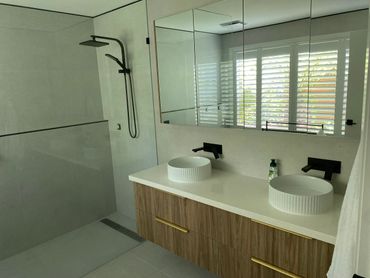 Modern bathroom with dual sinks and a walk-in shower.