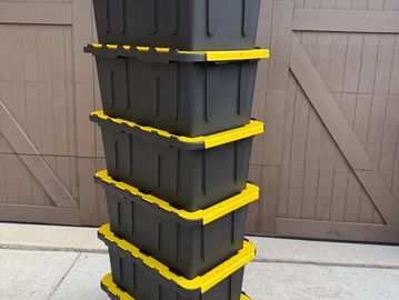 Stack of black and yellow storage bins.
