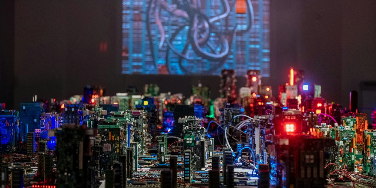 Miniature cityscape made from illuminated computer circuit boards.