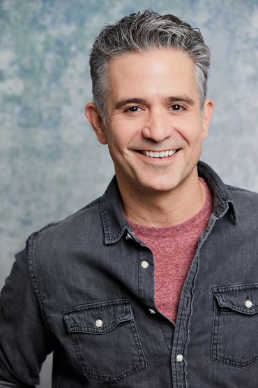 Smiling middle-aged man in casual wear.