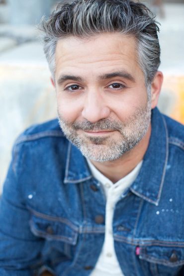 Man in denim jacket with salt-and-pepper beard.