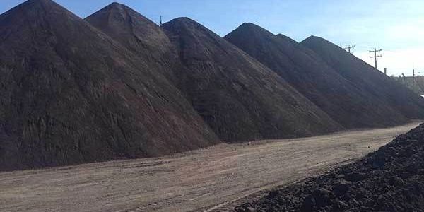 Large piles of coal are stacked outdoors.