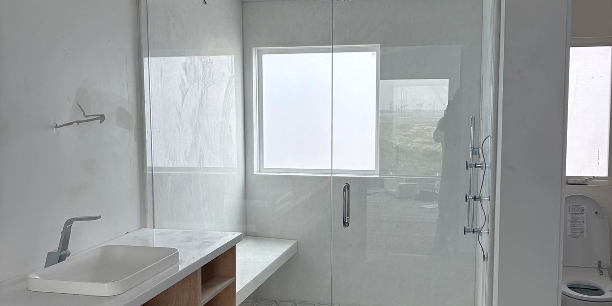 Modern bathroom with glass shower enclosure and minimalist design.