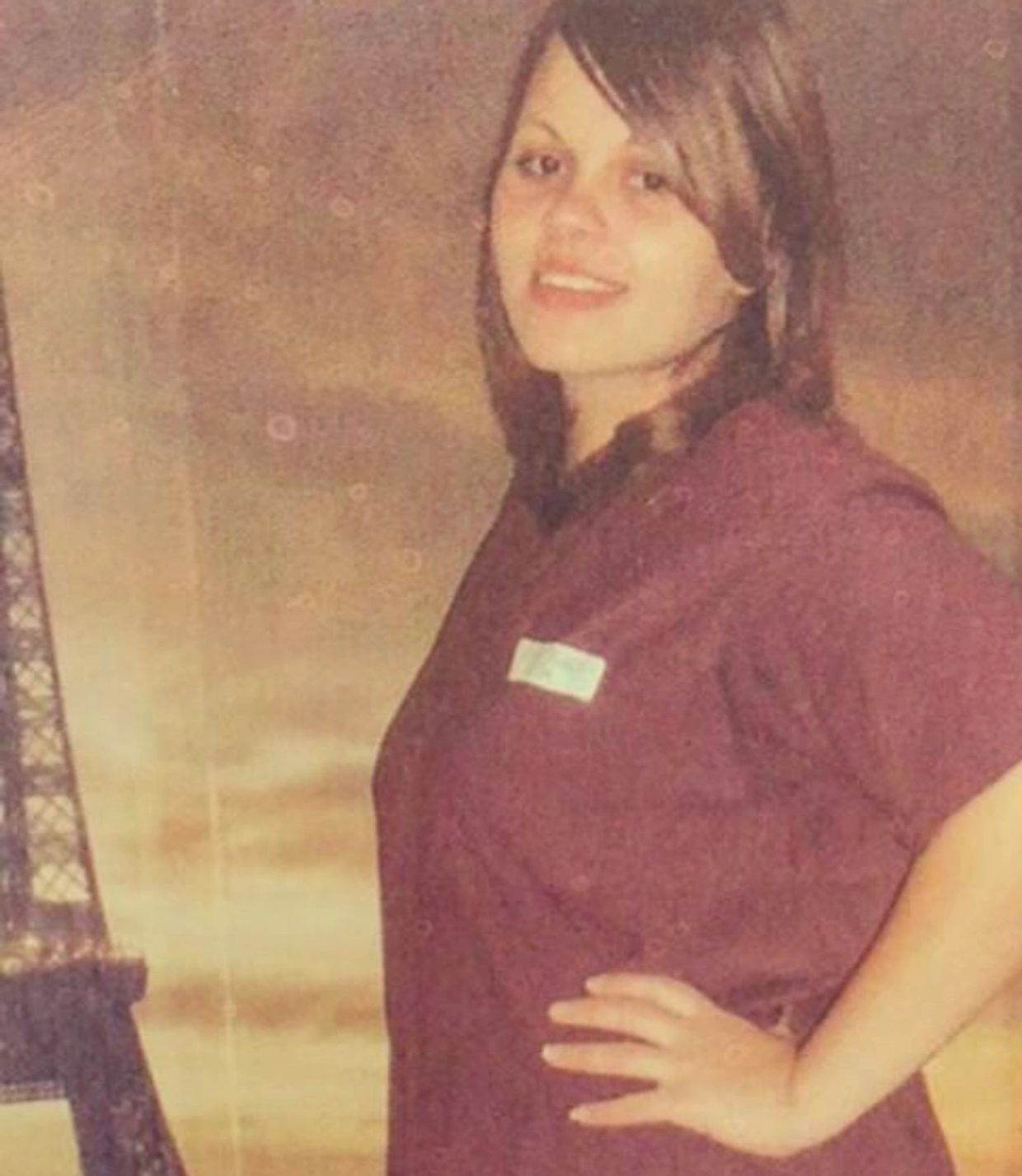 Young woman smiling with her hand on her hip.