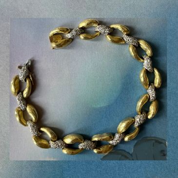 Gold and diamond bracelet with intricate leaf design.