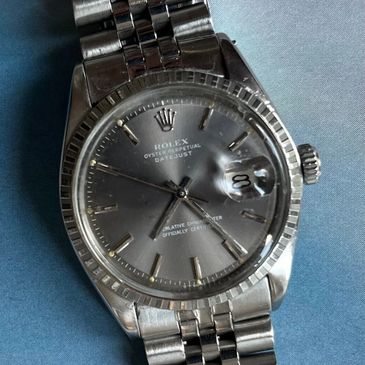 Close-up of a silver Rolex Oyster Perpetual Datejust watch.