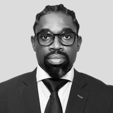Professional portrait of a man in a suit and tie with glasses.