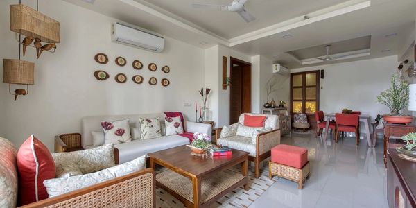 Cozy living room with wooden furniture and floral cushions in neutral tones.