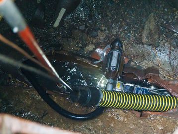 Robotic equipment in a narrow, wet underground tunnel.