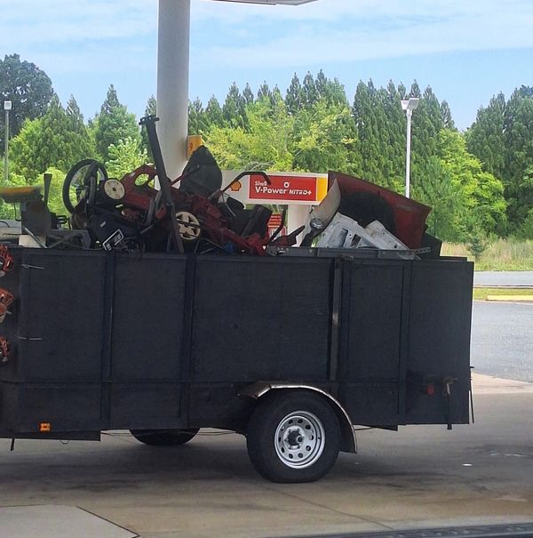Trailer filled with various equipment at a gas station.