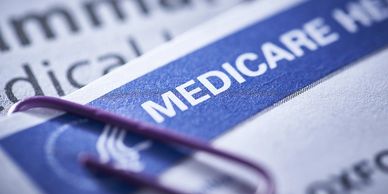 Close-up of a Medicare card with a paperclip attached.
