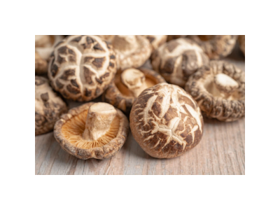 Close-up of fresh shiitake mushrooms on a wooden surface.