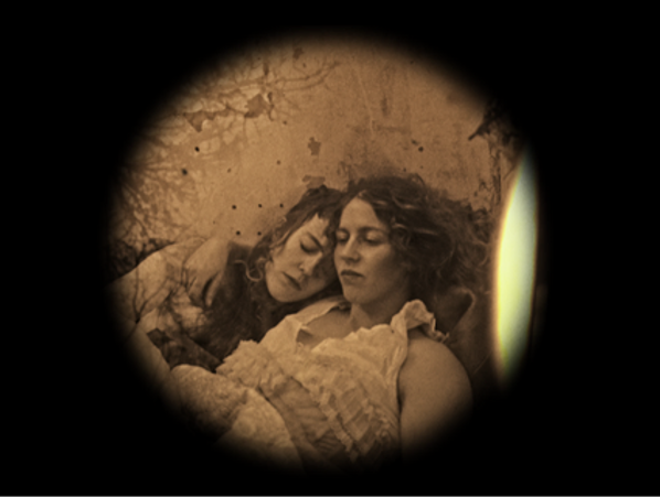 Two women resting closely together in a vintage sepia-toned photo.
