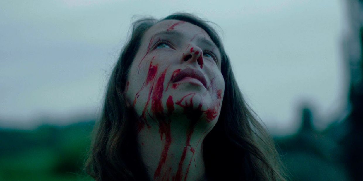 Woman with blood streaming down her face looking up.