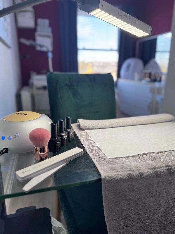 Nail salon workstation with manicure tools and UV lamp.