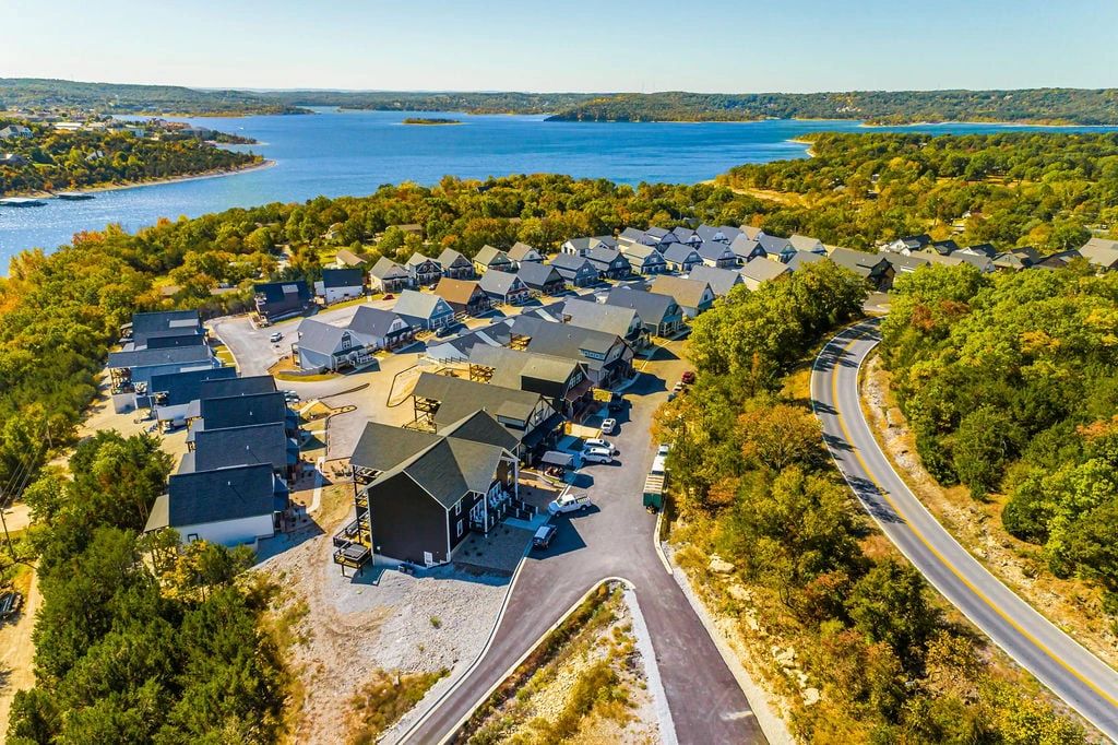 A lakeside residential neighborhood with many houses and surrounding greenery.