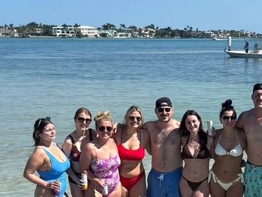 Group of friends enjoying a sunny day at the beach in swimwear.