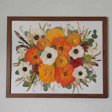 Framed artwork of colorful flowers on a wall.