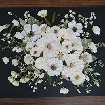 Arrangement of white flowers on black background.