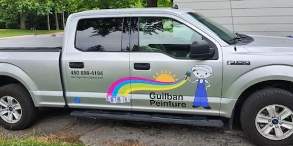 Silver pickup truck with colorful painting company advertisement on the door.
