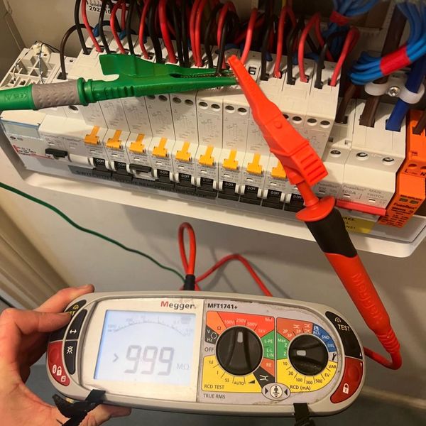 a fuse-board with a test instrument attached measuring the insulation resistance of a circuit