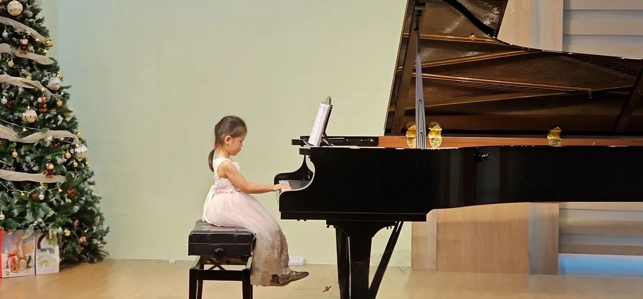 A 5 years old girl performing piano on stage