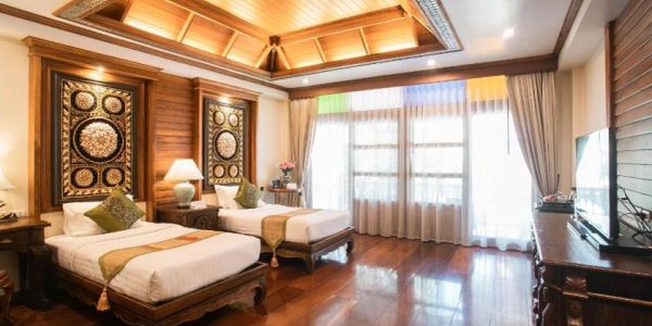 Elegant wooden-themed bedroom with twin beds and ornate decor.