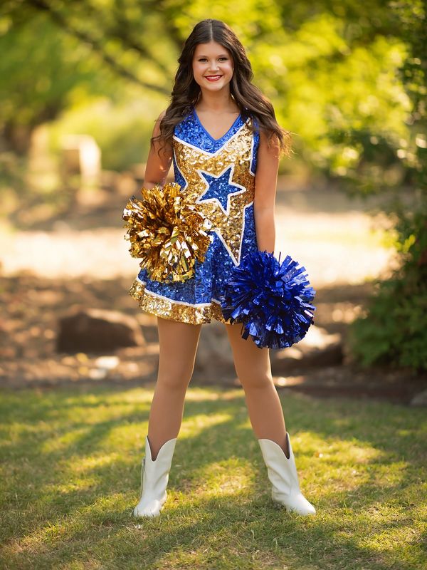 Young cheerleader in blue and gold outfit with pom-poms.