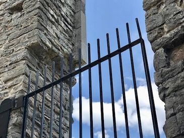 arche en pierre avec clôture en metal noir