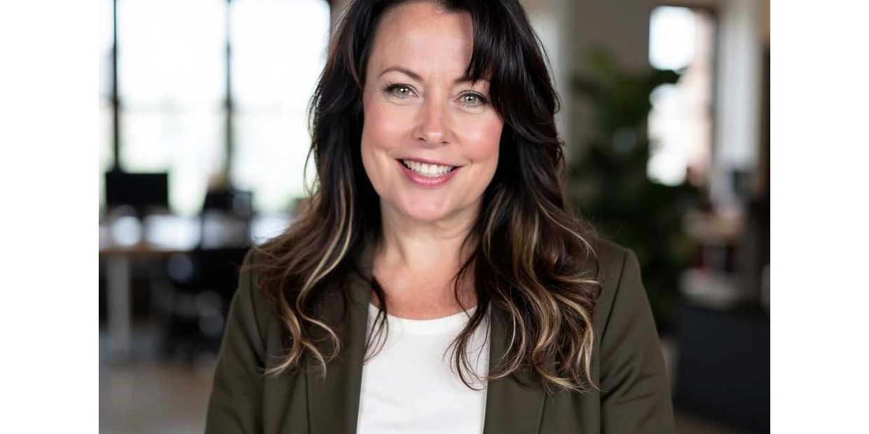 Smiling professional woman with wavy hair in office setting.