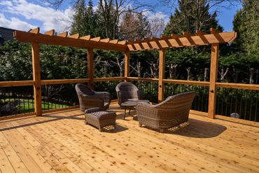 custom deck built with cedar deck boards, with a wood and metal railing. Built in Timber arbour wrap.