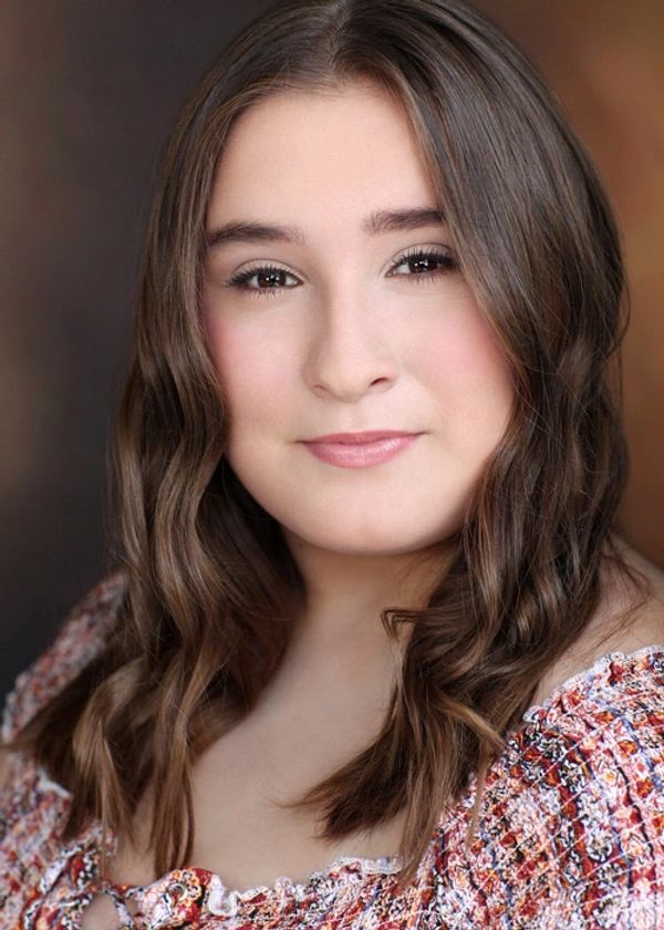Close-up portrait of a young woman with wavy hair and a soft smile.