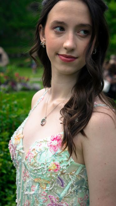 Young woman in a floral embroidered dress outdoors.