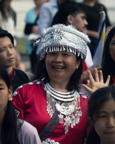 Woman in traditional dress smiling and waving.