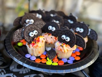 cupcakes with halloween decorations - chocolate sandwich cookies with eyes and bat wings