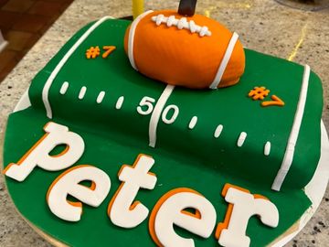 Football field cake with football topper, peter letters cut in fondant.