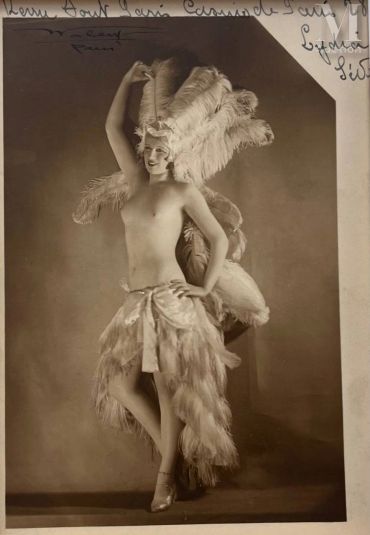Vintage showgirl in feather costume pose.