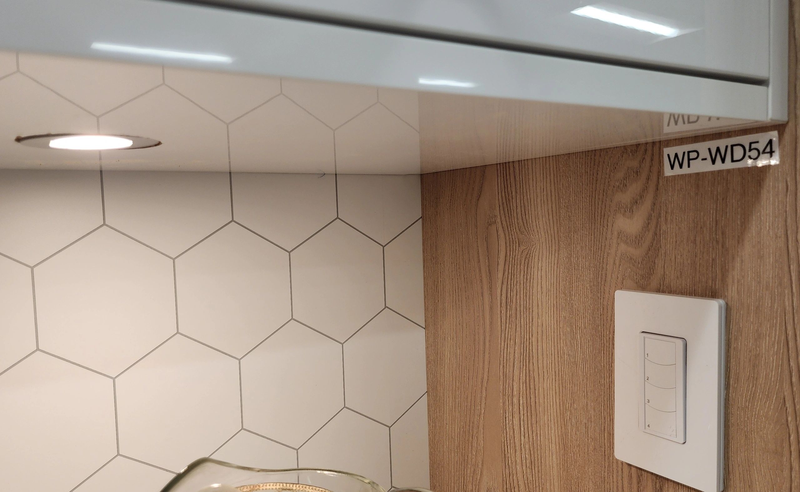 Wall with hexagonal tiles and a light switch.