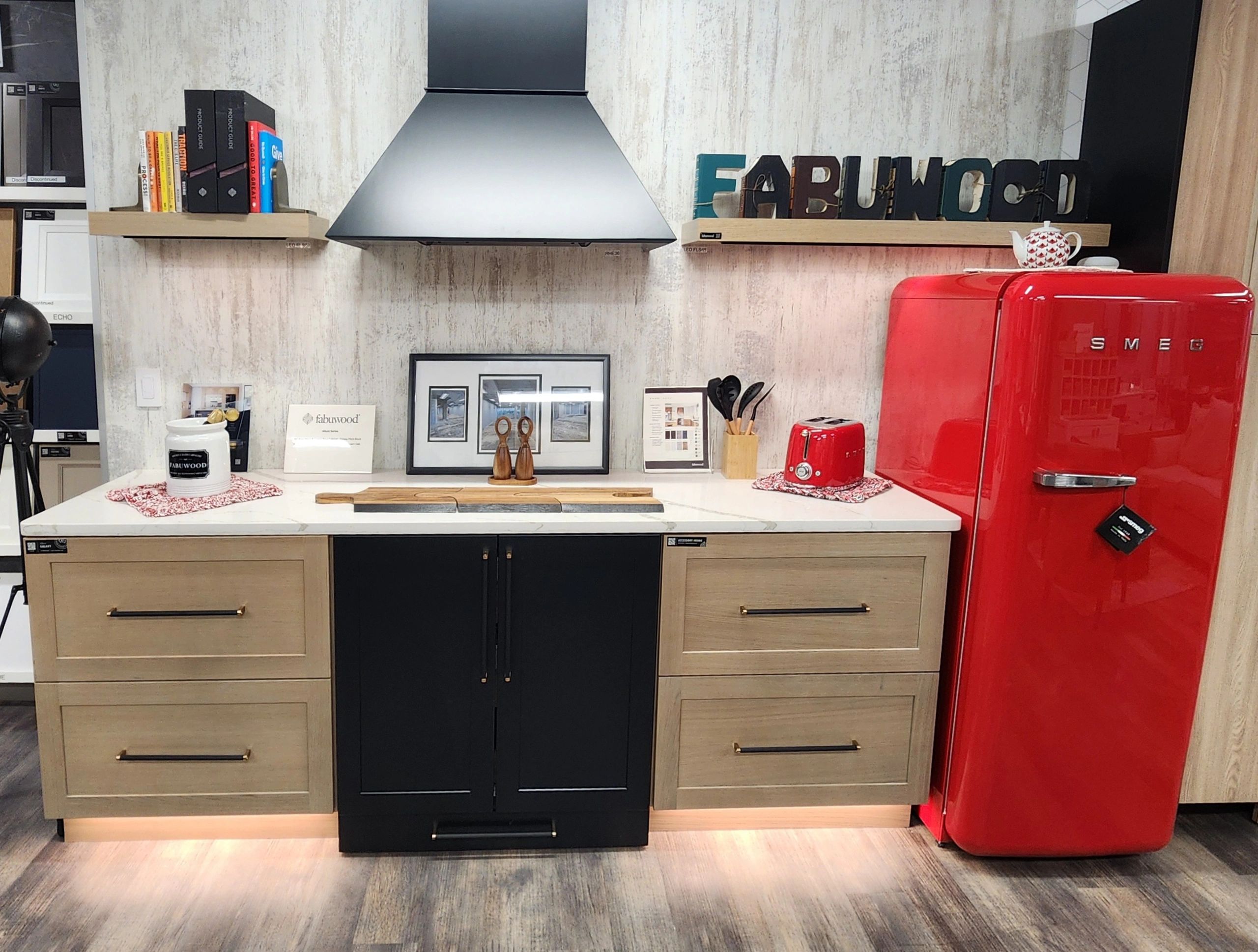 Modern kitchen setup with red SMEG fridge and black range hood.