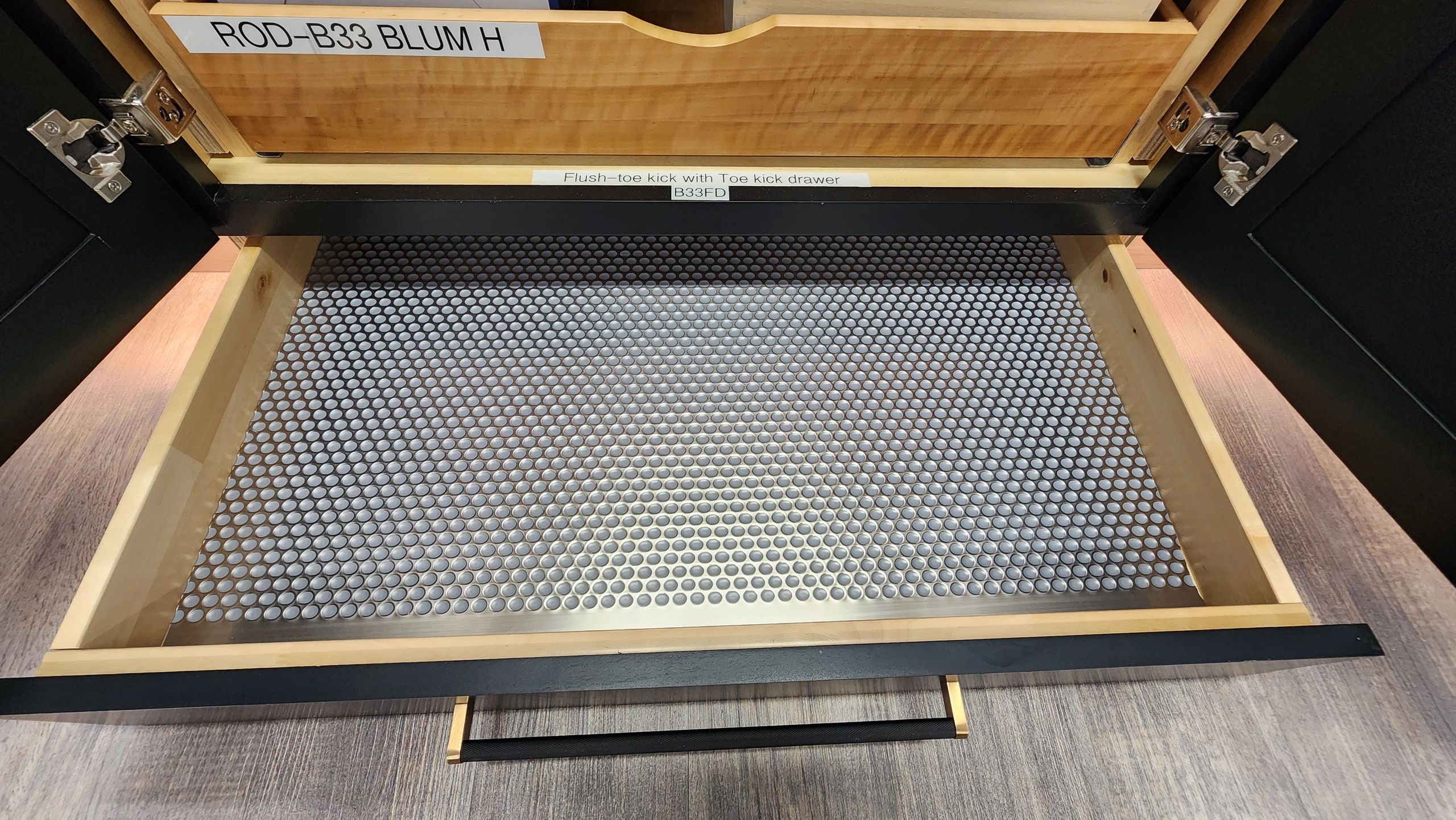 Empty kitchen drawer with metal sheet and labels.