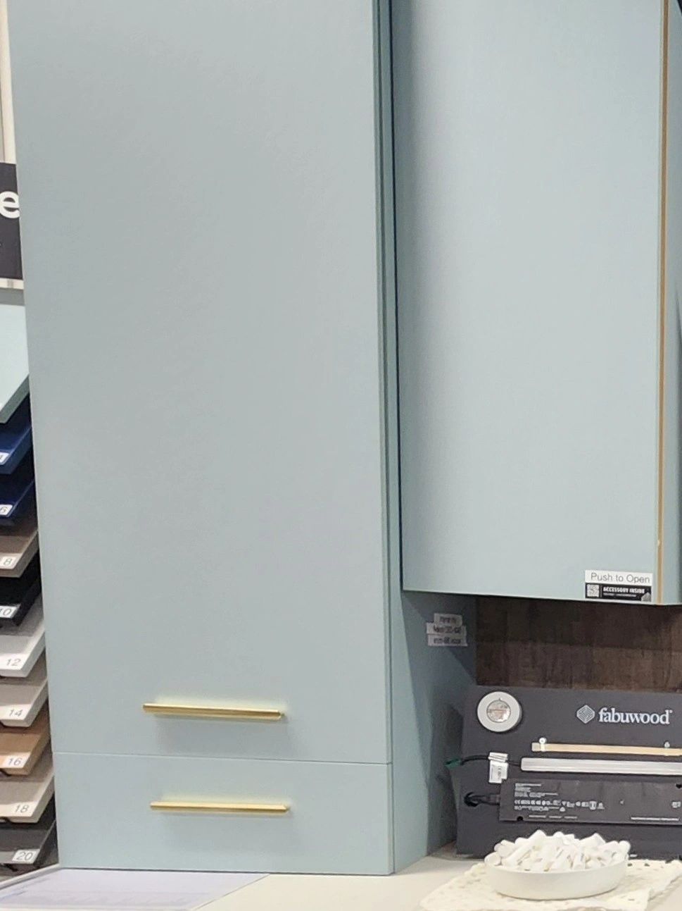 Modern light blue cabinet with gold handles.
