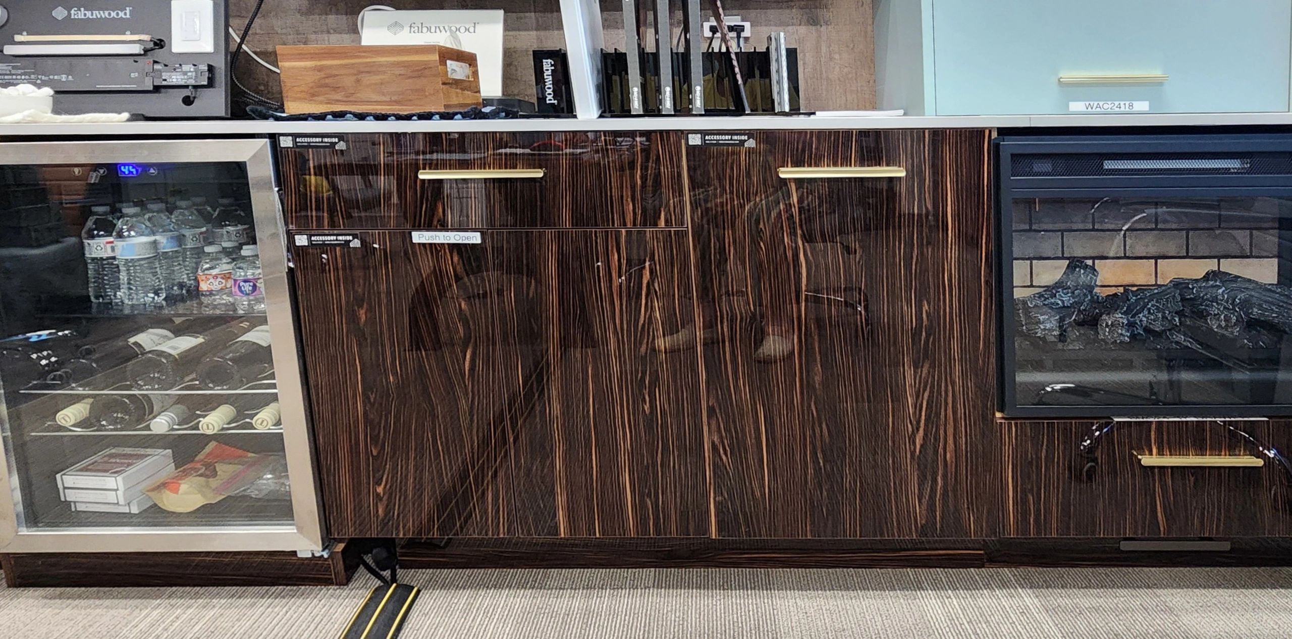 Wooden cabinet with wine fridge and fireplace.