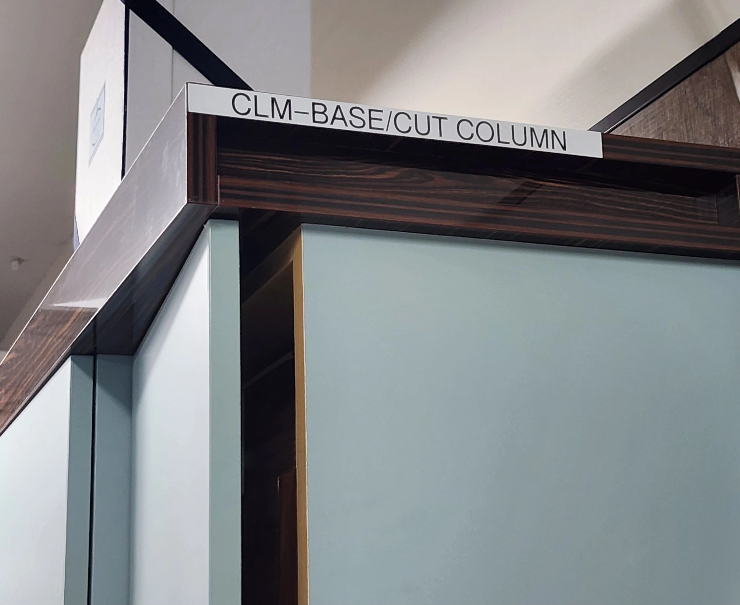 Label on a cabinet corner reading 'CLM-BASE/CUT COLUMN'.