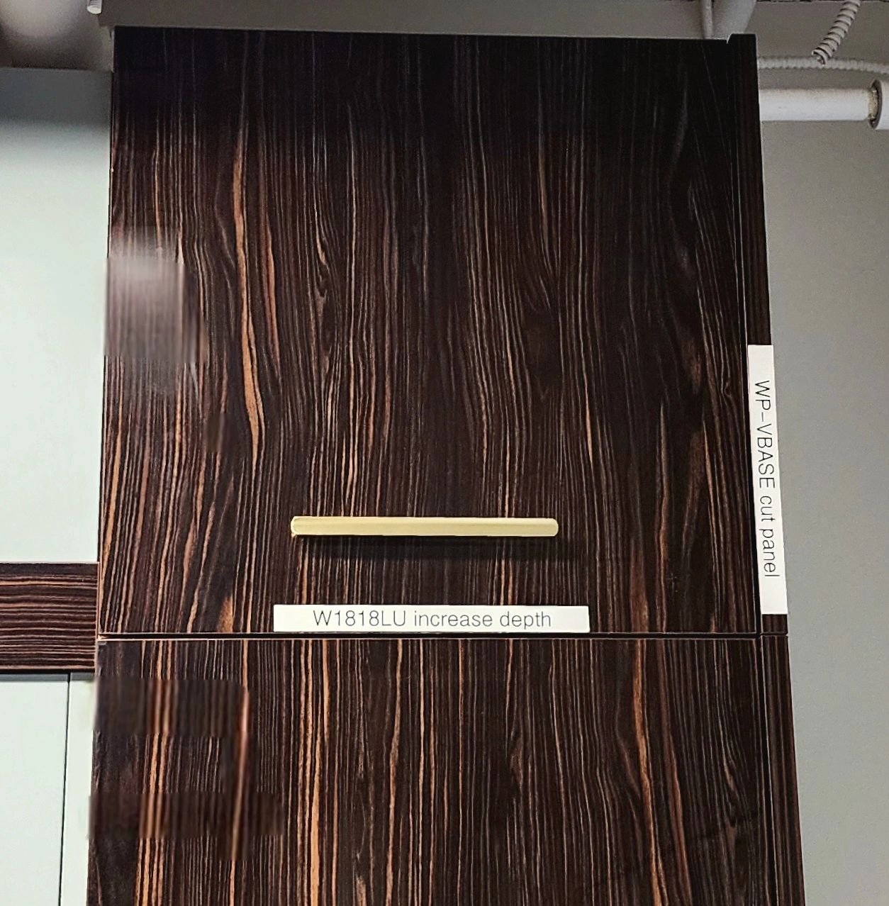 Dark wood panel with labels and a light handle.