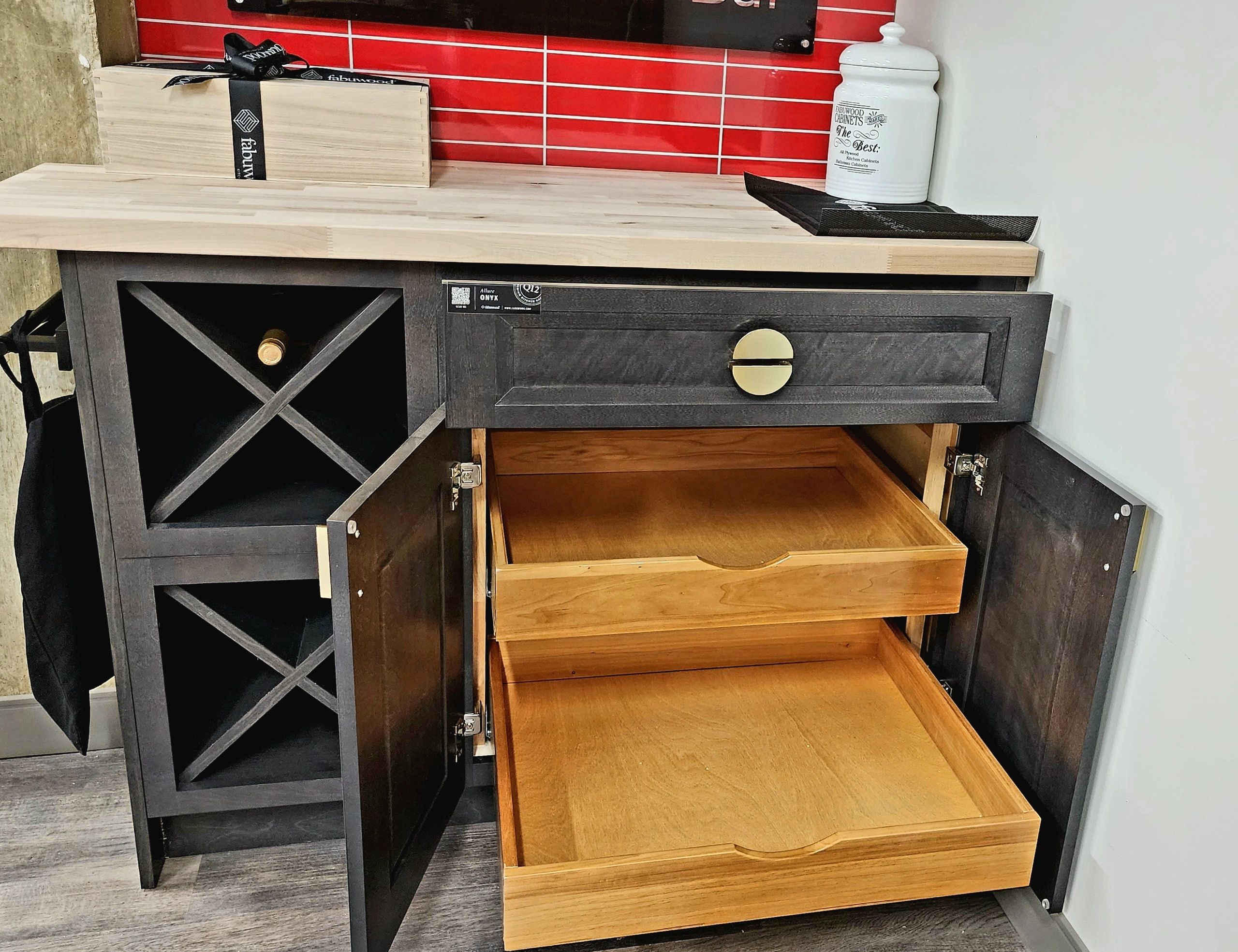Black cabinet with open drawers and wine storage under a wooden countertop.