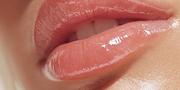 Close-up of glossy, well-moisturized lips with a natural pink hue.