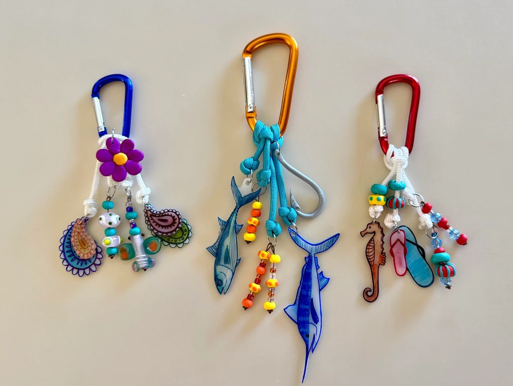 Three colorful keychains with beads and ocean-themed charms.